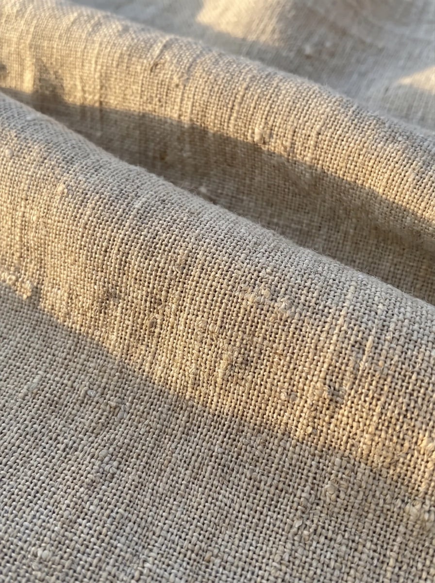Close view of undyed linen weave in warm side light.